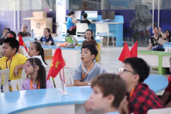 Các bạn nhỏ mở to mắt chăm chú lắng nghe hướng dẫn chơi Cờ Đông Sơn.