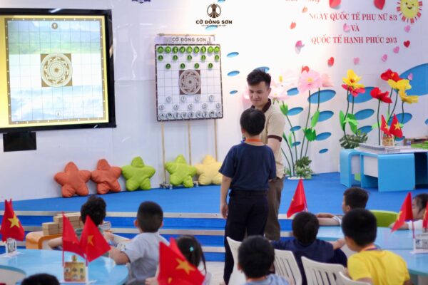 Một bạn nhỏ tự tin giao lưu với người hướng dẫn về kinh nghiệm chơi Cờ Đông Sơn.