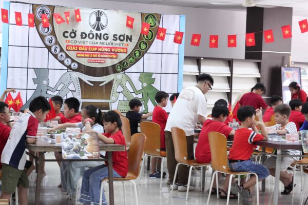 Cận cảnh hai kỳ thủ nhí mặc áo phông cờ đỏ sao vàng đang tập trung cao độ thi đấu ván cờ Tiến Cung gay cấn tại Giải đấu Cờ Đông Sơn lần 2.
