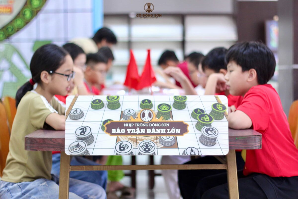 Thông điệp "Nhịp trống Đông Sơn - Báo trận đánh lớn" nổi bật trước khung cảnh các kỳ thủ nhí đang tập trung cao độ tại Giải đấu Cờ Đông Sơn lần 2.
