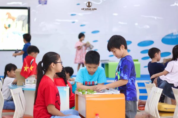 Các kỳ thủ nhí thảo luận và thực hành cách tính điểm thi đấu trực tiếp trên ván cờ trong bu