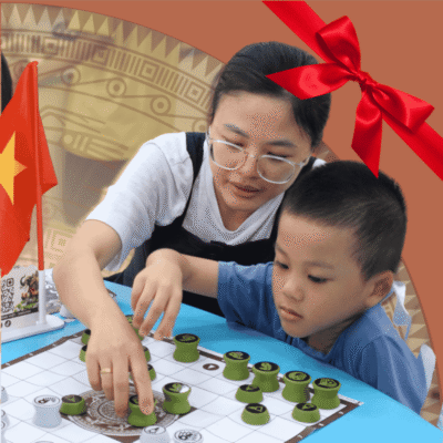 Hình ảnh người mẹ ân cần hướng dẫn cậu con trai nhỏ chơi Cờ Đông Sơn, thể hiện ý nghĩa thiết thực của món quà tặng văn hóa trong việc giáo dục tư duy và gắn kết tình thân.