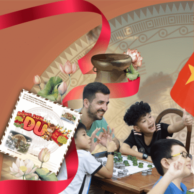 Hình ảnh người nước ngoài vui vẻ trải nghiệm Cờ Đông Sơn cùng các em nhỏ Việt Nam bên cạnh quốc kỳ và hoa sen, minh họa cho sức mạnh kết nối của một món quà tặng văn hóa.