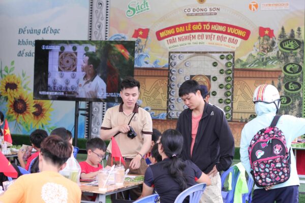Đội ngũ ban tổ chức nhiệt tình hướng dẫn luật chơi Cờ Đông Sơn cho các em nhỏ và phụ huynh tại sự kiện Đường sách TP. Thủ Đức.