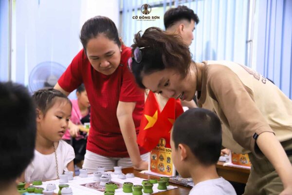 Huấn luyện viên tận tình hướng dẫn các kỳ thủ nhí và phụ huynh trong giờ thực hành Cờ Đông Sơn tại Khóa hè Cờ Đông Sơn 2026 ở clb Lam Sơn.