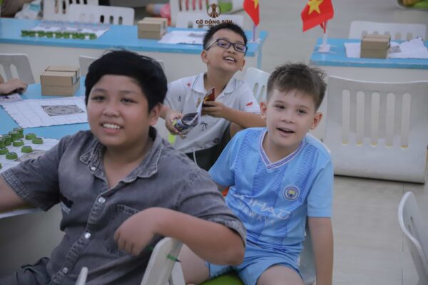 Biểu cảm tươi vui, rạng rỡ của nhóm các bạn nhỏ nam học viên khi cùng nhau tham gia học tập và kết bạn tại Khóa hè Cờ Đông Sơn.