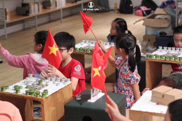 Các học viên nhí hào hứng tương tác cùng lá cờ đỏ sao vàng trong giờ thực hành.